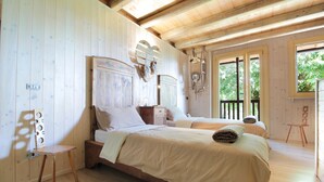 A wooden-paneled bedroom with two beds, a wooden chair, and a small table. - Holiday Home in Feltre with Garden BBQ (Pedavena)