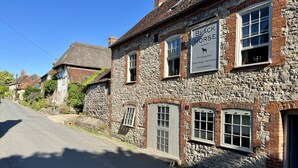 Un bâtiment en pierre avec une enseigne indiquant « Black Horse », un pub et un restaurant, et arborant un logo représentant un cheval.