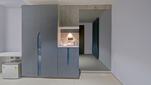 Una cocina moderna con un refrigerador empotrado, una encimera con un hervidor y un dispensador de agua.