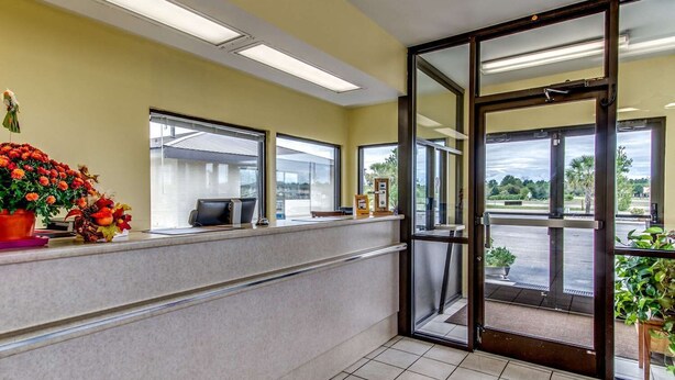 A reception area with a counter, a computer, and a window with a view of the parking lot. - Econo Lodge Lumberton NC (Lumberton)