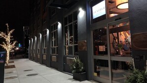 A building with a sign reading "FEATHER FASHION" and a large illuminated sign above the entrance. - The Feather Factory (Long Island City)