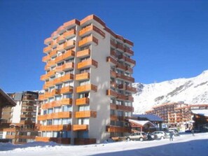A multi-story hotel with balconies, located in a snowy mountainous area. - Cozy Studio with Mountain Corner - Sleeps 3, Balcony, South-West View, Val Thorens (Val Thorens)