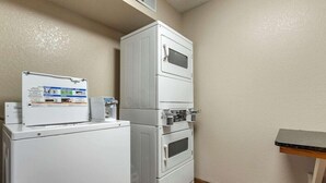 A compact laundry area with a washer, dryer, and stacked appliances. - Quality Inn Creston (Creston)