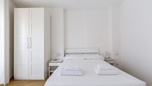 A minimalist hotel room with a large bed, two bedside tables, a wardrobe, and a nightstand. - The apartment is located in a stunning location, almost impossible to find! You are in the authentic heart of Milan, between Sant'Ambrogio district, renowned above all for the church of Santa Maria delle Grazie and the Catholic University and the charm o (Milano)