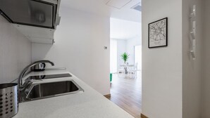 A modern kitchen with stainless steel appliances, a white countertop, and a dining area with a table and chairs. - The apartment is located in a stunning location, almost impossible to find! You are in the authentic heart of Milan, between Sant'Ambrogio district, renowned above all for the church of Santa Maria delle Grazie and the Catholic University and the charm o (Milano)