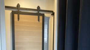 Puerta corrediza con acabado de madera y marco negro.
