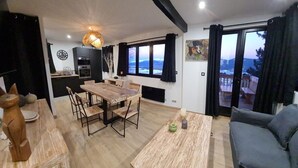 Una cocina moderna con comedor, sofá y vistas al exterior.