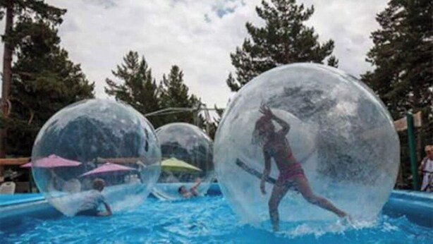 People inside transparent spheres in a swimming pool. - Bel Appartement Dans un Chalet vue sur le lac (Les Angles)