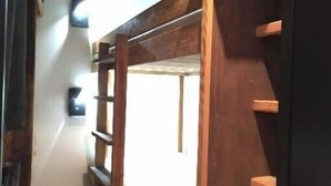 A narrow room with a wooden bunk bed and a black wardrobe. - Bel Appartement Dans un Chalet vue sur le lac (Les Angles)