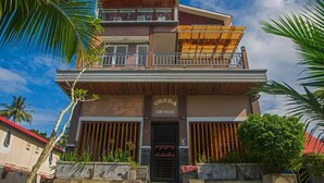 Un edificio de dos pisos con un letrero que dice "OSEDA SURF HOUSE".
