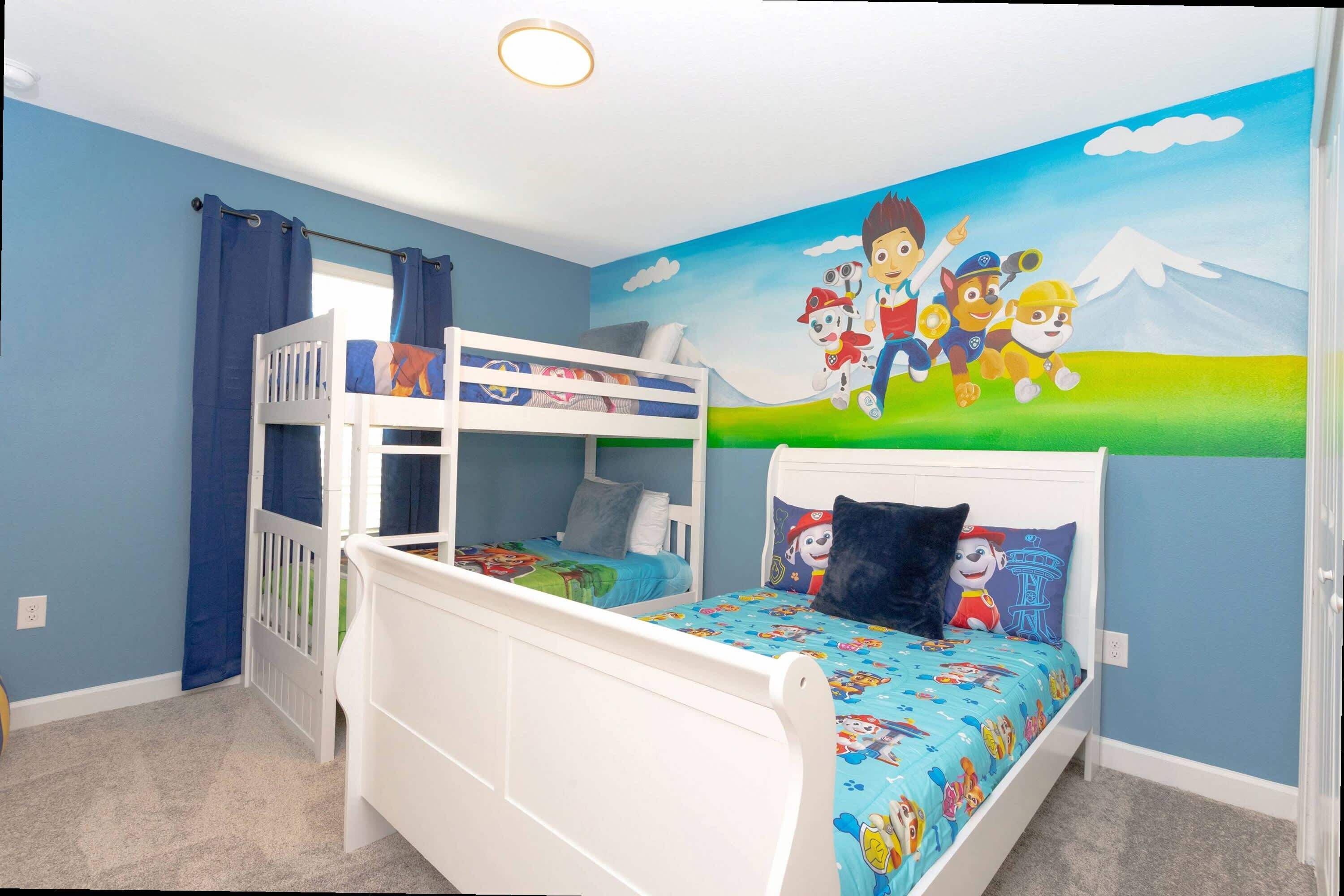 Une chambre d’enfant avec des lits superposés, une fresque murale et une fenêtre avec des rideaux.