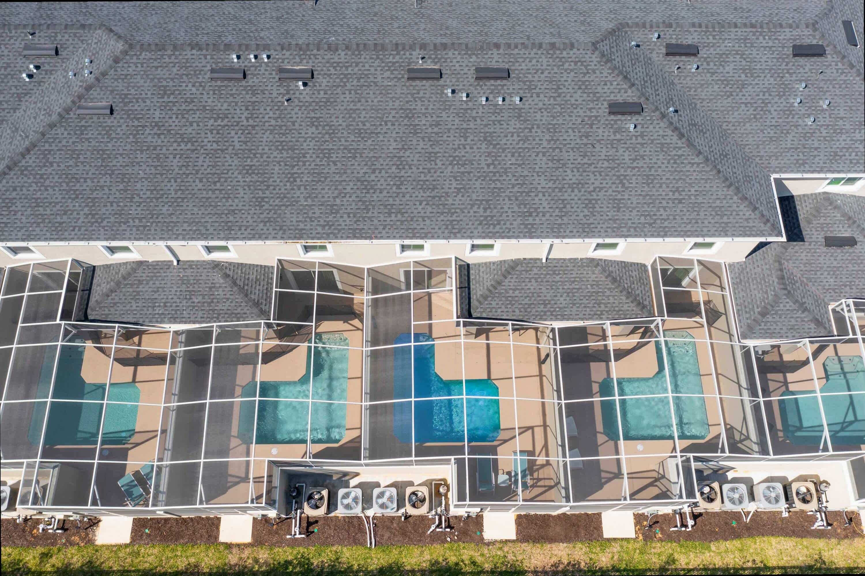 A large building with a rooftop covered in solar panels and multiple air conditioning units.