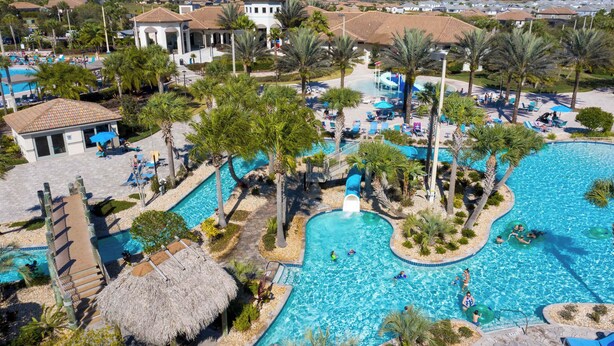 A resort with multiple swimming pools, palm trees, and lounge areas.