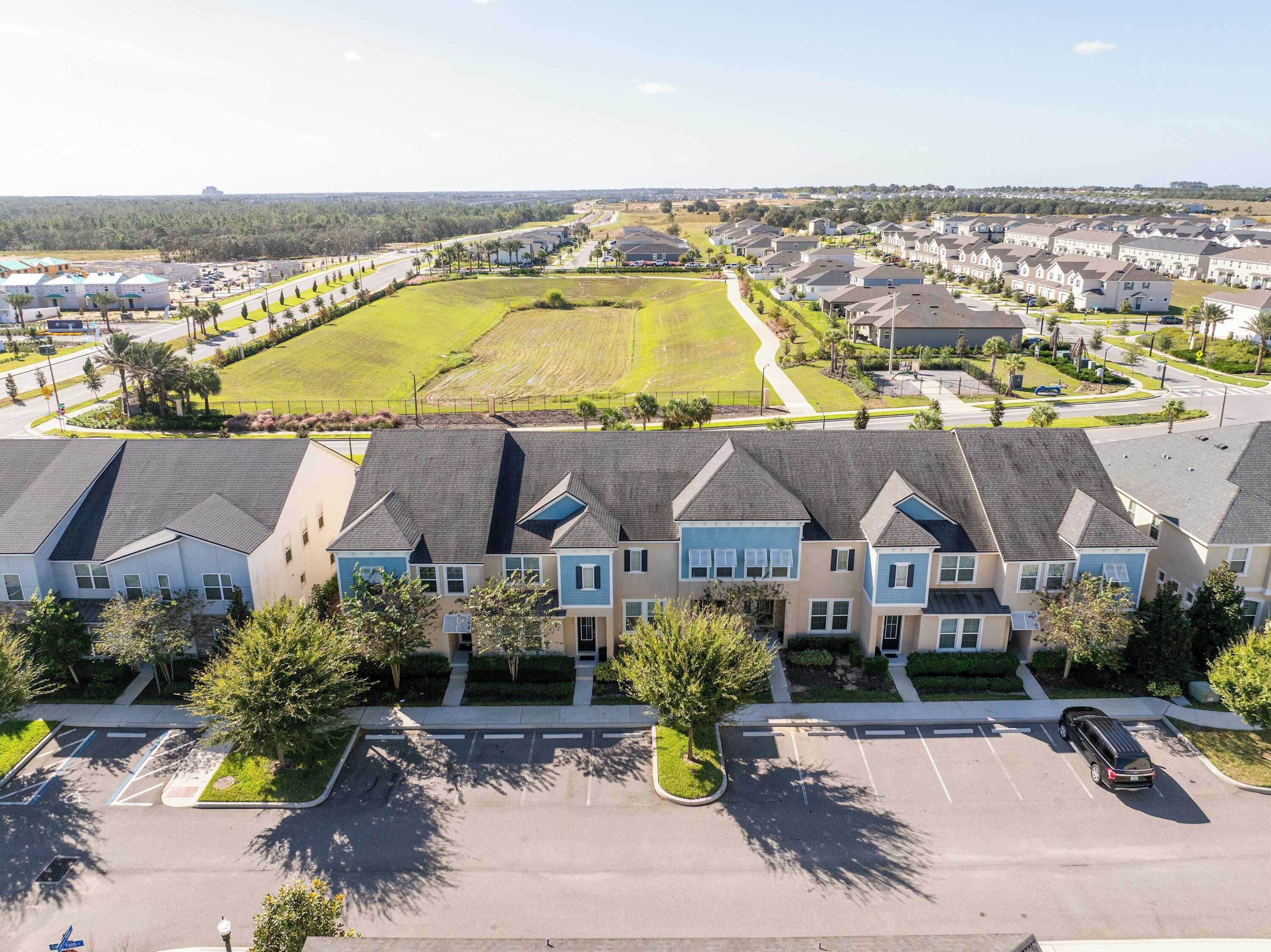 Un quartier résidentiel avec des maisons modernes, un parking et un espace vert.