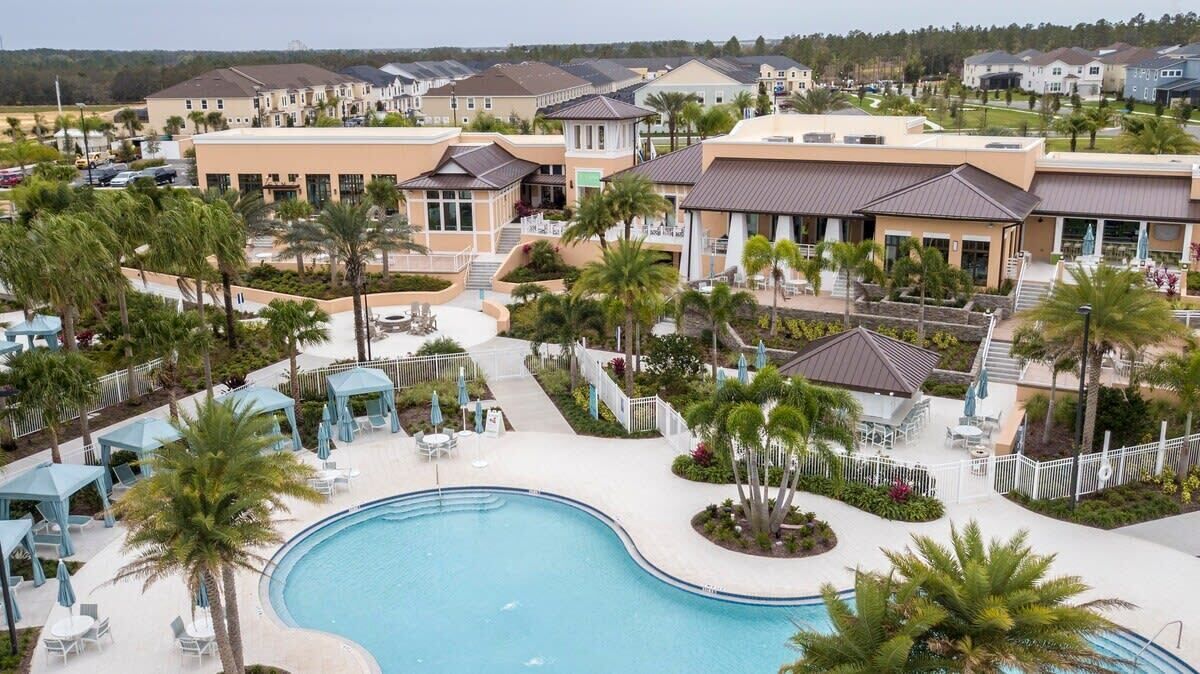 A resort with a swimming pool, lounge areas, and multiple buildings with balconies.