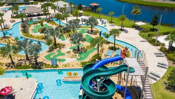 A water park with a large pool, slides, and a golf course.