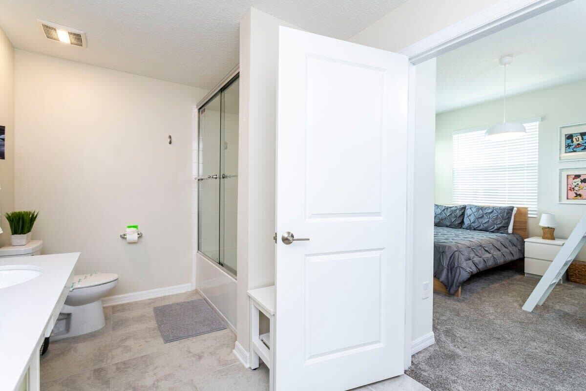 A modern bathroom with a shower, toilet, and sink.