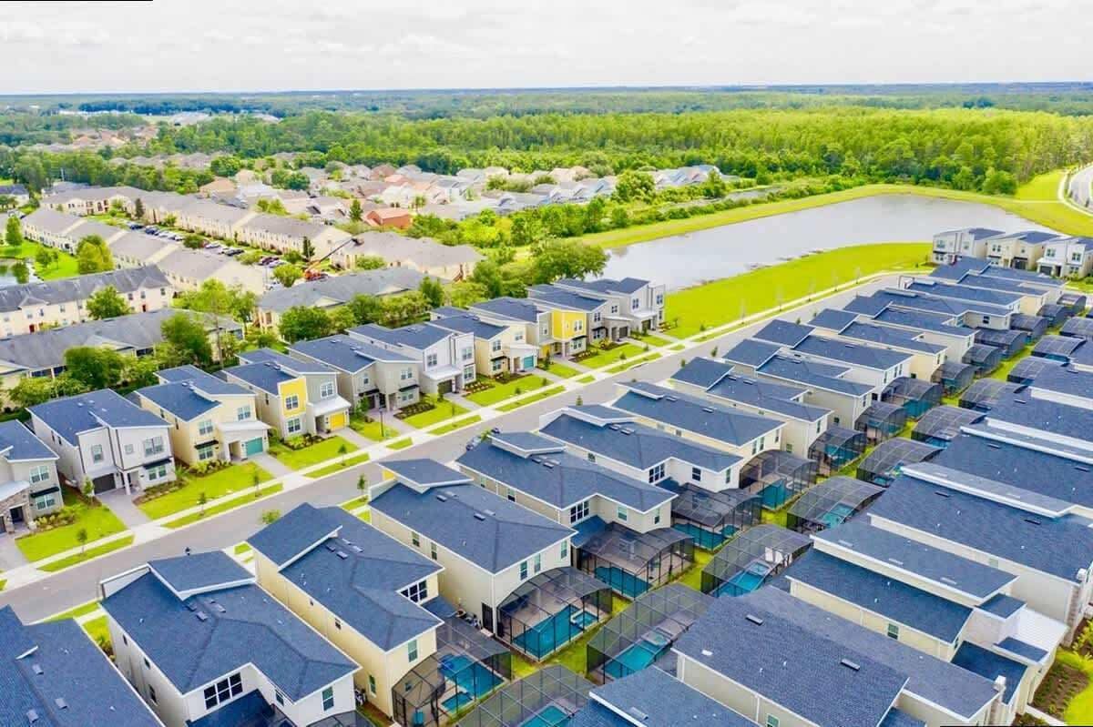 Zona residencial com casas modernas, uma grande área de água e um parque arborizado.