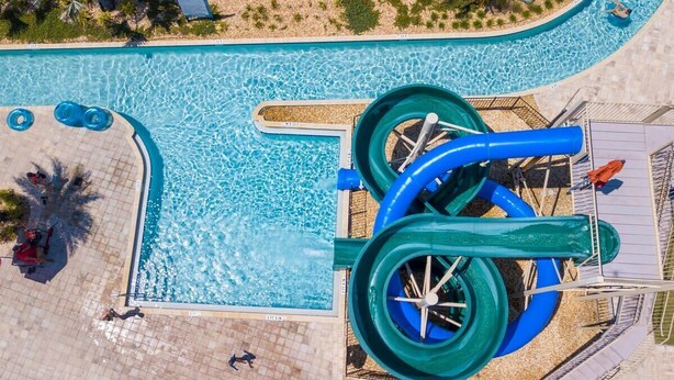A pool with a water slide and lounge chairs. - Gorgeous 4Bd w/ Screened Pool Close to Disney 4289 (Kissimmee)