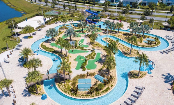 A resort with a large swimming pool, water slides, and a basketball court.