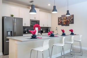 Resortwoning | Privékeuken | Een koelkast met diepvriezer, een microgolfoven, een oven, een kookplaat