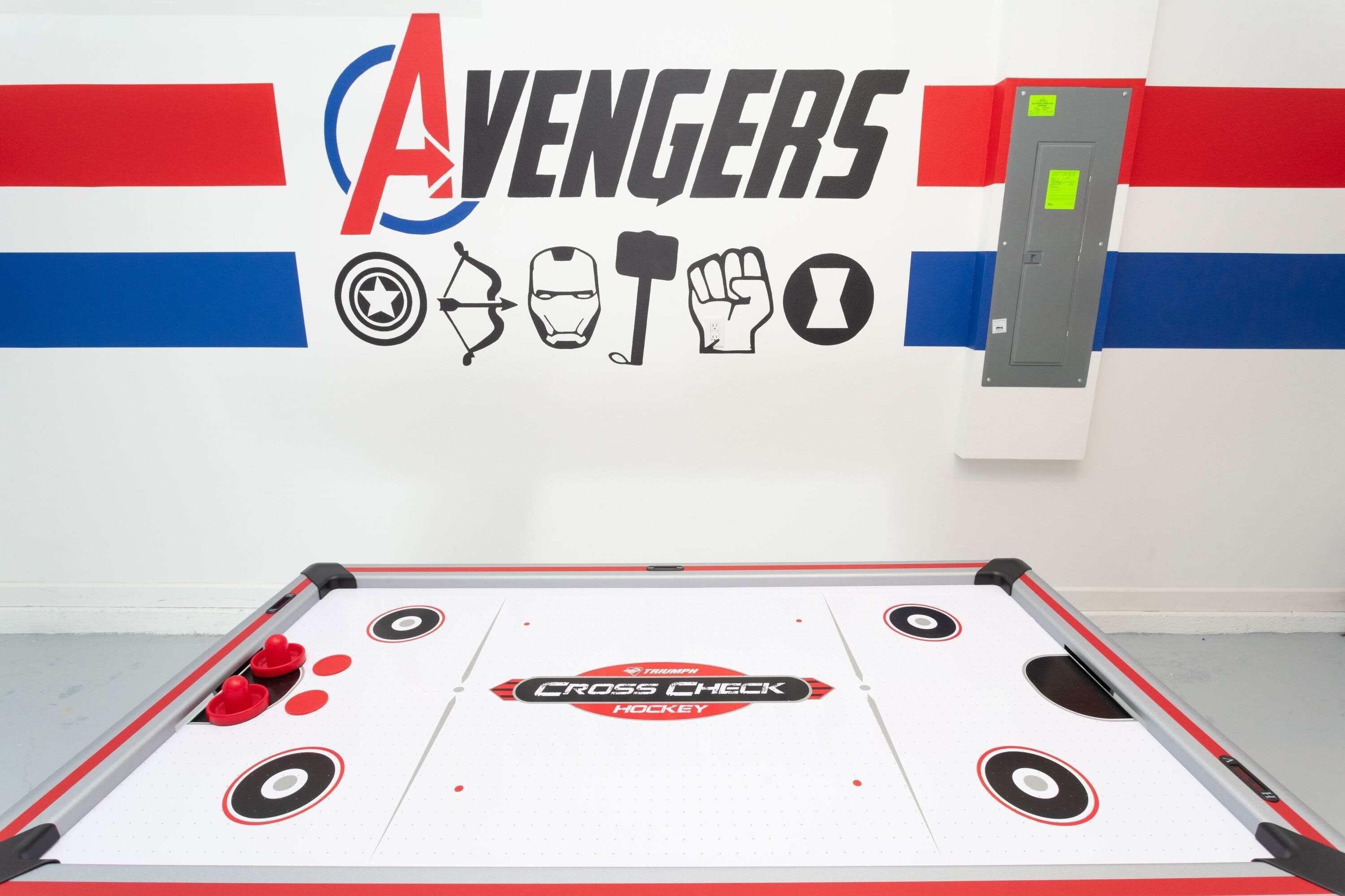 Ein Hockeytisch mit dem Schriftzug 'Cross Check Hockey' und Wandgestaltung zum Thema Avengers.
