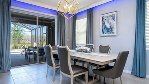 A dining area with a large table, chairs, and a chandelier. - Stunning 5Bd w/ Pool Close to Disney @ Solterra 7829 (Davenport)