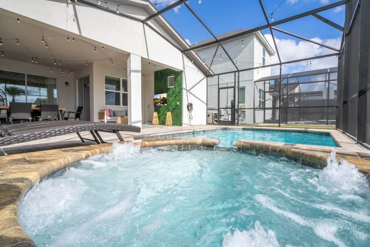 Een moderne binnenzwembadruimte met een jacuzzi, ligbedden en een ruimte met glazen wanden.