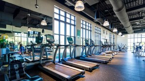 Ein Fitnessstudio mit mehreren Laufbändern, Ergometer und Krafttrainingsgeräten.