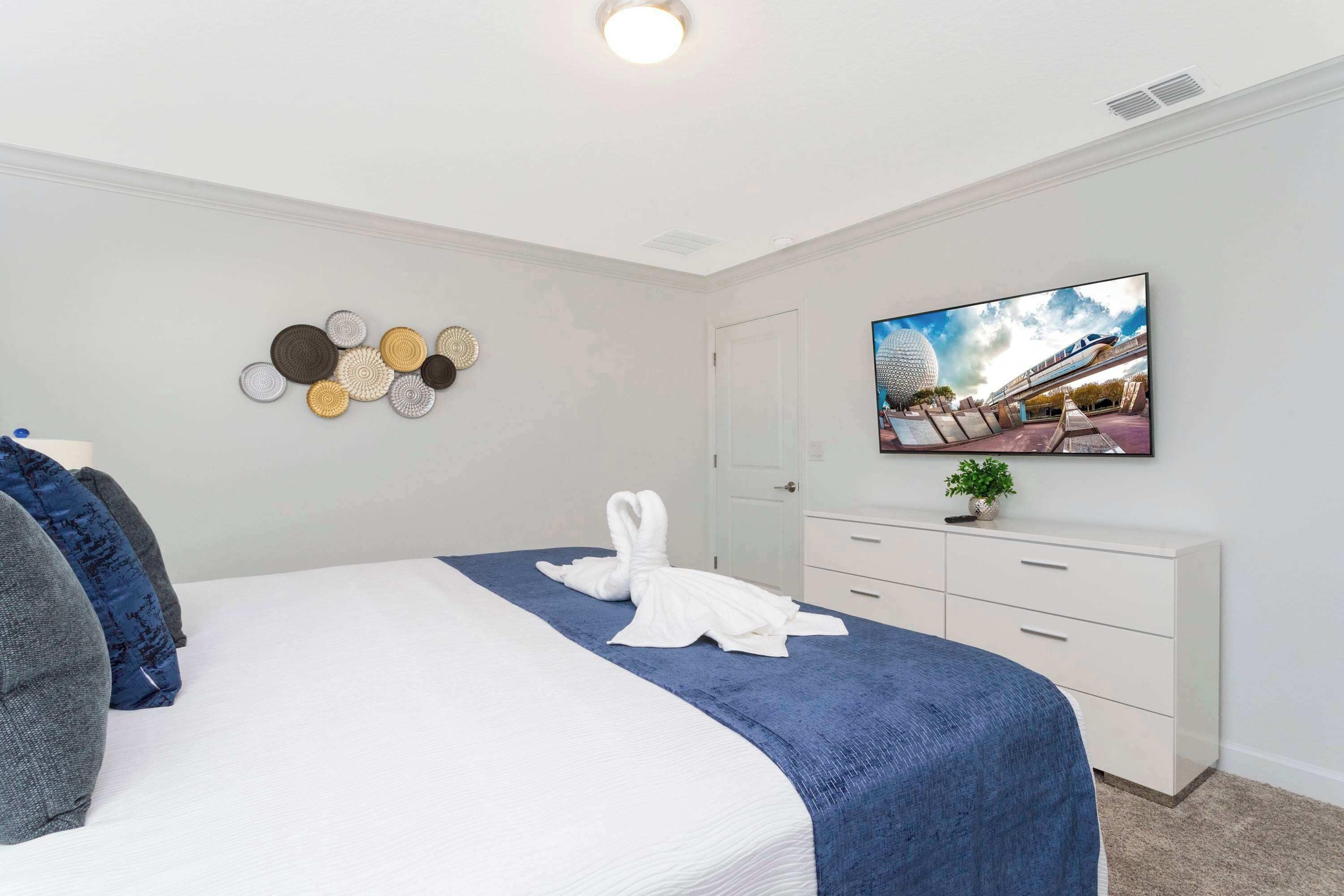 Een hotelkamer met een bed, een flatscreen televisie, een dressoir en wanddecoratie.