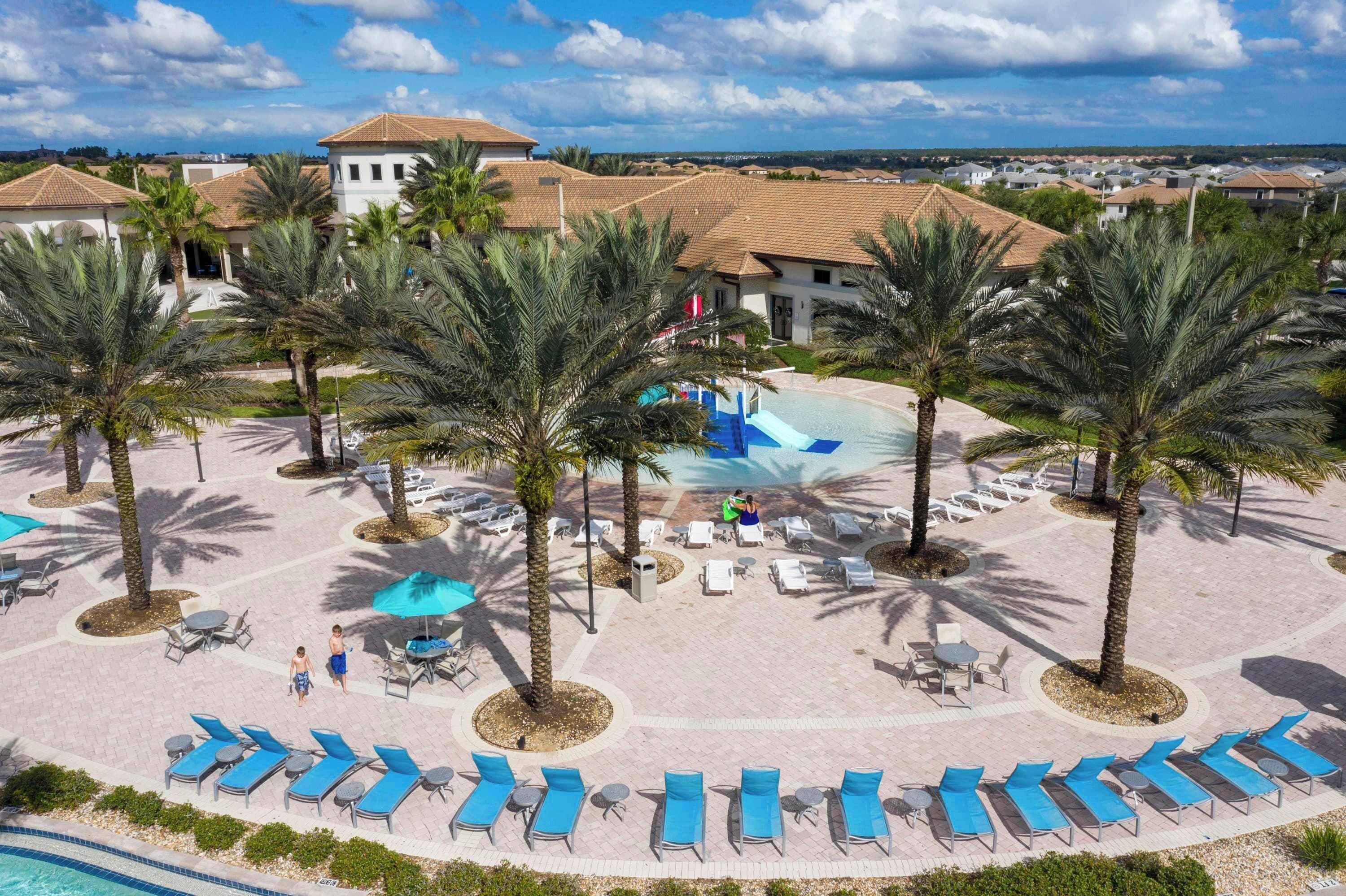 Ein Resort mit Poolbereich, Palmen und Liegestühlen.