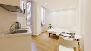 A modern kitchen with a sink, stove, and window with blinds. - GuestHost - Studio Milan-Corso Magenta! Ac & Wifi! (Milano)