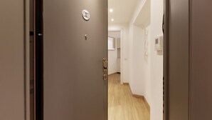 A hallway with a door, a light switch, and a thermostat on the wall. - GuestHost - Studio Milan-Corso Magenta! Ac & Wifi! (Milano)