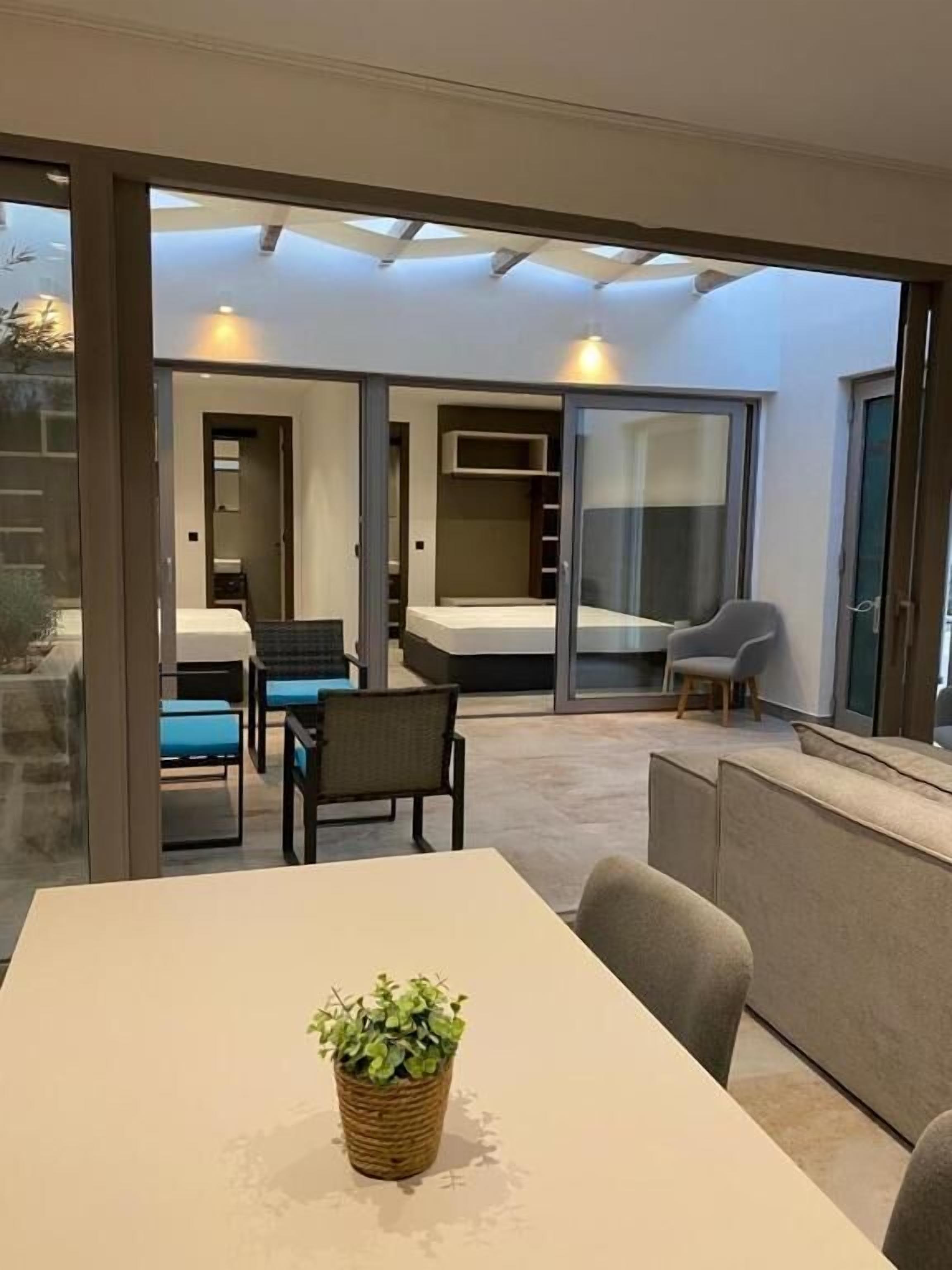 Un intérieur moderne comprenant un coin repas, un canapé et une petite table agrémentée d’une plante.
