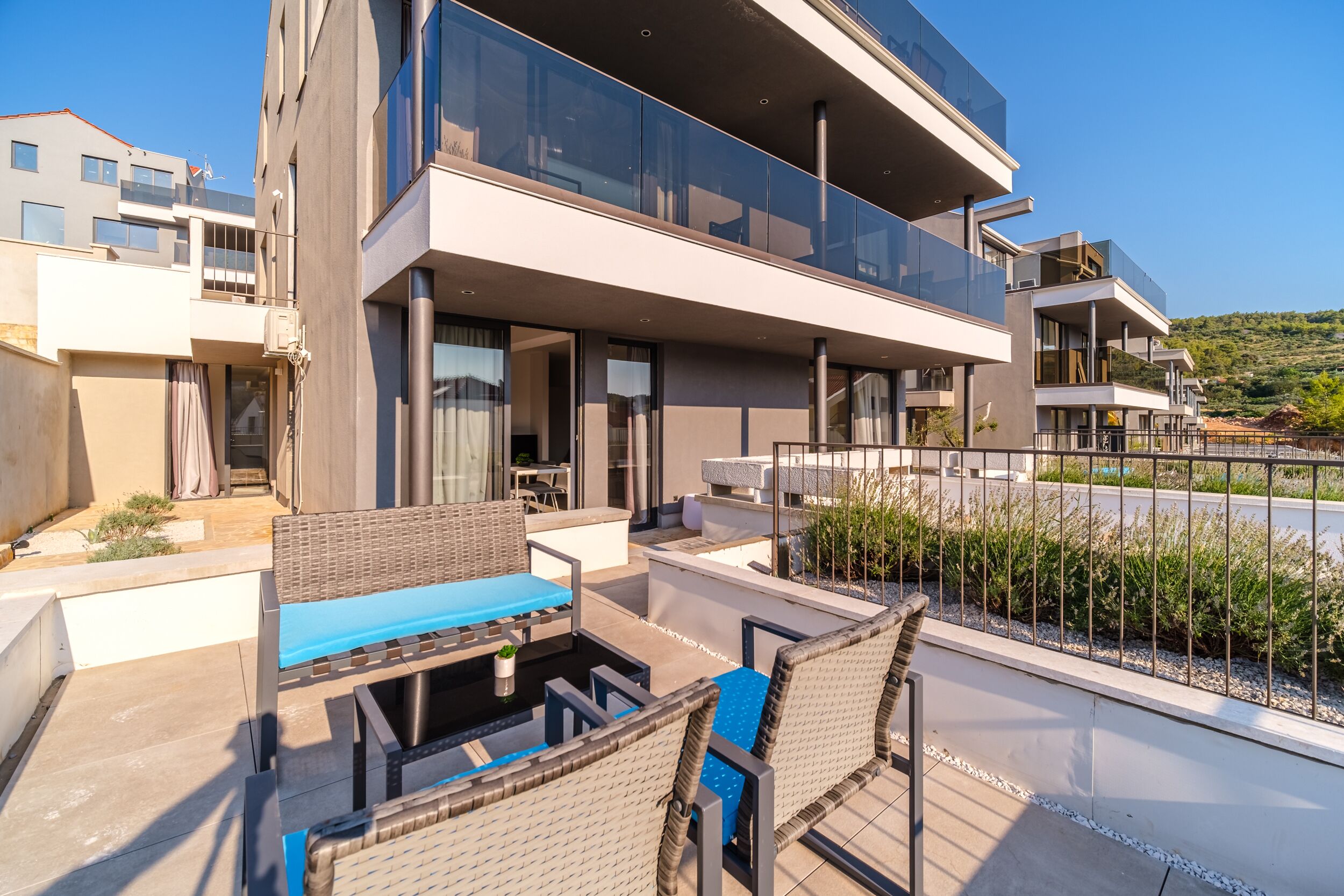 A modern outdoor patio with a dining area, a pool, and a view of the surrounding buildings.