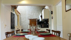 A dining area with a wooden table set for four, surrounded by chairs.