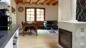 A spacious living area with a wooden dining table, a sofa, and a fireplace.