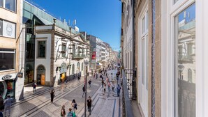 A bustling street with historic buildings, a clear blue sky, and people walking.