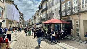 A bustling street with pedestrians, cafes, and shops.