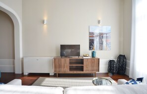 Un soggiorno con un mobile in legno, una televisione e un quadro appeso al muro.