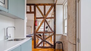 Une cuisine avec une structure en poutres apparentes, un évier et un coin repas à l’arrière-plan.