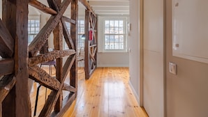 A hallway with wooden beams, a wooden floor, and a door with a light switch. - Amazing Duplex Two-Bedroom Apart with Views (Oporto)