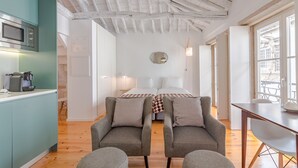 Ein modernes Zimmer mit einer Küche, zwei Betten und einem Essbereich.