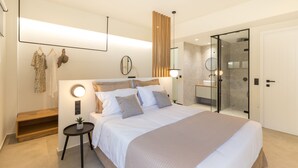 Camera da letto moderna con un letto grande, comodini, uno specchio rotondo e una cabina armadio.