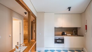 A compact kitchen with white cabinets, a built-in oven, and a sink.