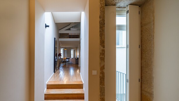 A staircase leading to a second-floor area with a dining area and a view of the outdoors.