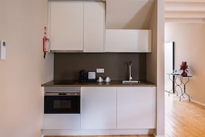 Una cocina compacta con lavavajillas, horno y un lavamanos pequeño.