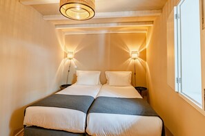 A double bed with two nightstands, a hanging light fixture, and a window on the right. - Comfortable 1BR Apt for 3 with balcony in Center (Oporto)