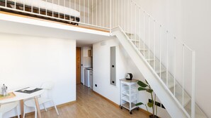 A modern apartment with a staircase, a dining area, and a kitchenette. - GuestHost - Cozy APT on 2 levels Milan-Corso Magenta! (Milano)