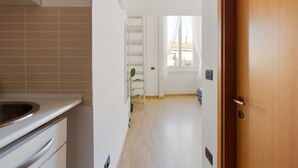 A kitchen with a sink, cabinets, and a window with curtains. - GuestHost - Cozy APT on 2 levels Milan-Corso Magenta! (Milano)